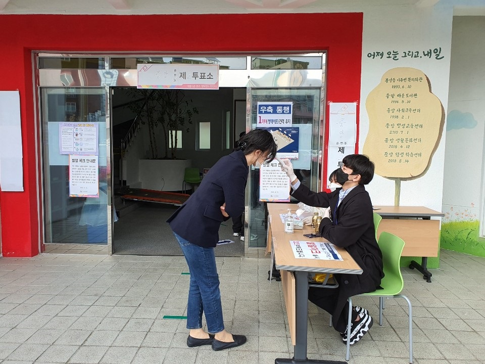 ▲21대 총선 투표일인 15일 경남 창원시내 한 투표소 입구에서 한 시민이 발열 체크를 하고 있다. (뉴시스)