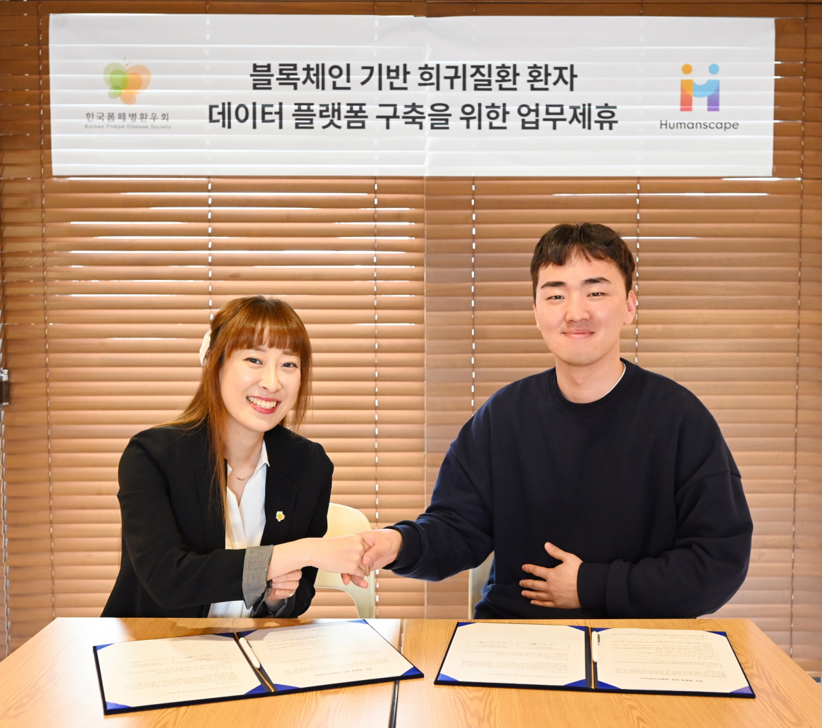 ▲한국폼페병환우회 임지나 회장(왼쪽)과 휴먼스케이프 장민후 대표가 업무협약을 체결하고 기념 촬영을 하고 있다.  (사진제공=휴먼스케이프)