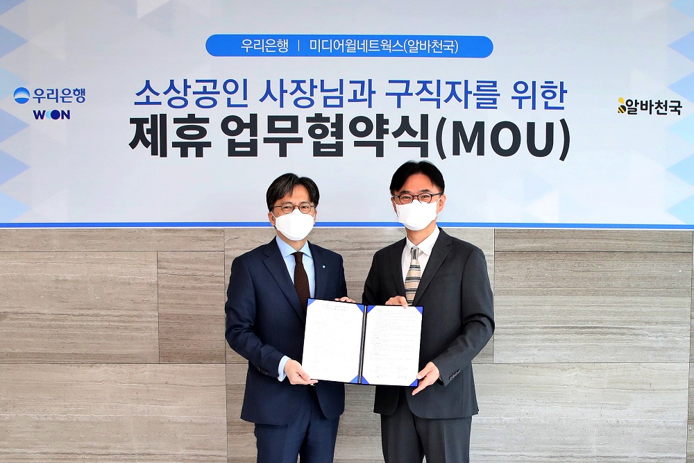 ▲황원철(왼쪽) 우리은행 디지털금융그룹 상무와 공선욱 미디어월네트웍스 대표가 16일 서울 중구 우리은행 본점에서 협약 후 기념촬영을 하고 있다. (사진제공=우리은행)