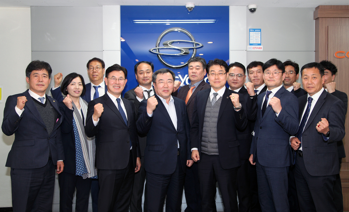 ▲예병태 쌍용차 사장(사진 첫째줄 가운데)과 수도권 지역 대리점협의회 대표들이 지난 20일 서울사무소에서 간담회를 마친 뒤 위기극복 의지를 다지며 구호를 외치고 있다. (사진제공=쌍용차)