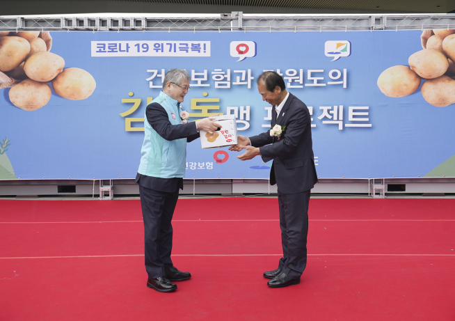 ▲김용익 국민건강보험공단 이사장(사진 왼쪽)이 22일 건보공단 원주 사옥에서 최문순 강원도지사로부터 감자를 전달받고 있다. (사진제공=국민건강보험공단)