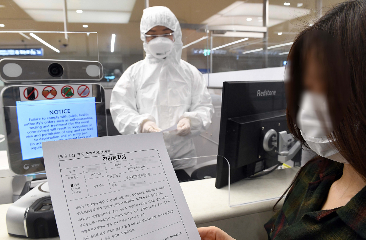 ▲신종 코로나바이러스 감염증(코로나19) 사태가 장기화되고 있는 가운데 전신 방호복을 입은 인천국제공항 출입국 외국인청 입국심사관이 유증상자 전용 입국심사대에서 입국심사뒤 자가격리 지침을 설명하고 있다.  (뉴시스)