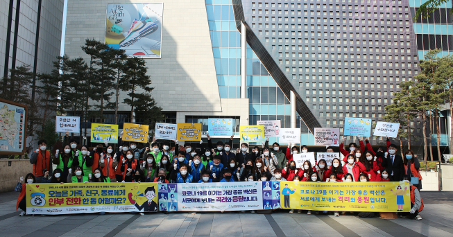 ▲28일 아침 GS파워 사회공헌팀원들과 지역 복지관 직원들이 안양 범계역 입구에서 출근 시민들에게 마스크,물수건 등을 전달하는 행사를 가지고 코로나19 극복을 위한 구호를 외치고 있다. (사진제공=GS파워)