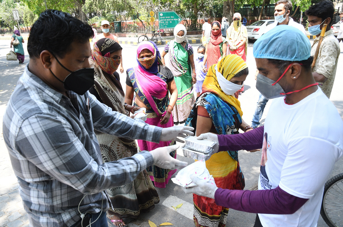 ▲인도 뉴델리에서 4월 21일(현지시간) 인도청년의회 멤버들이 코로나19로 일자리를 잃은 노숙자와 실직자들에게 무료로 음식을 나눠주고 있다. 뉴델리/EPA연합뉴스
