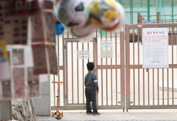 ▲3월31일 오후 서울 용산구 한 초등학교에서 한 어린이가 닫혀진 문을 바라보고 있다.  (연합뉴스)