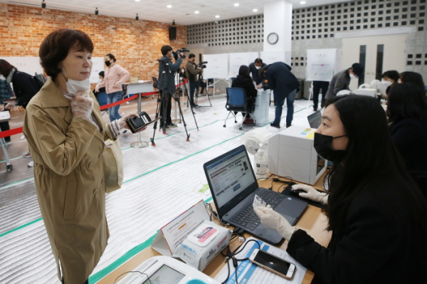 ▲제21대 국회의원선거 사전투표가 시작된 10일 광주 서구 서구문화회관에 마련된 사전투표소에서 한 시민이 마스크를 잠시 내리고 신분 확인을 받고 있다. (연합뉴스)