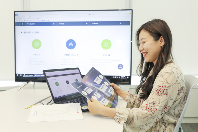 ▲롯데케미칼 직원이 동반성장보고서를 보고 있다. (사진제공=롯데케미칼)