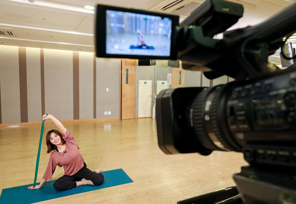▲ 현대백화점 무역센터점 문화센터 강의실에서 김은아 필라테스 강사가 ‘밴드필라테스 홈트레이닝 스트레칭’ 강좌를 카메라 등 중계 장비 앞에서 진행하고 있다. (사진제공=현대백화점)