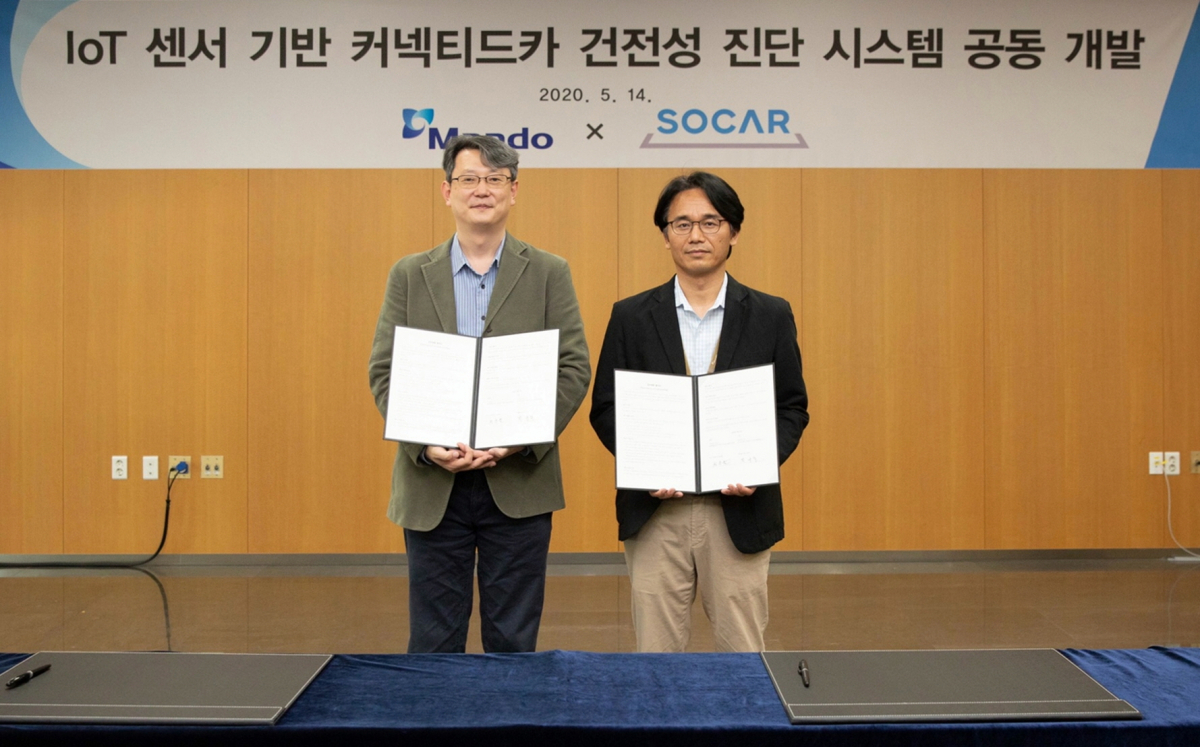 ▲원종필 쏘카 기술총괄책임(왼쪽)과 박규식 만도 F3랩 실장이 ‘IoT 센서 기반 커넥티드카 건전성 진단 시스템 개발’을 위한 업무 협약’을 체결한 뒤 기념촬영을 하고 있다. (사진제공=쏘카)