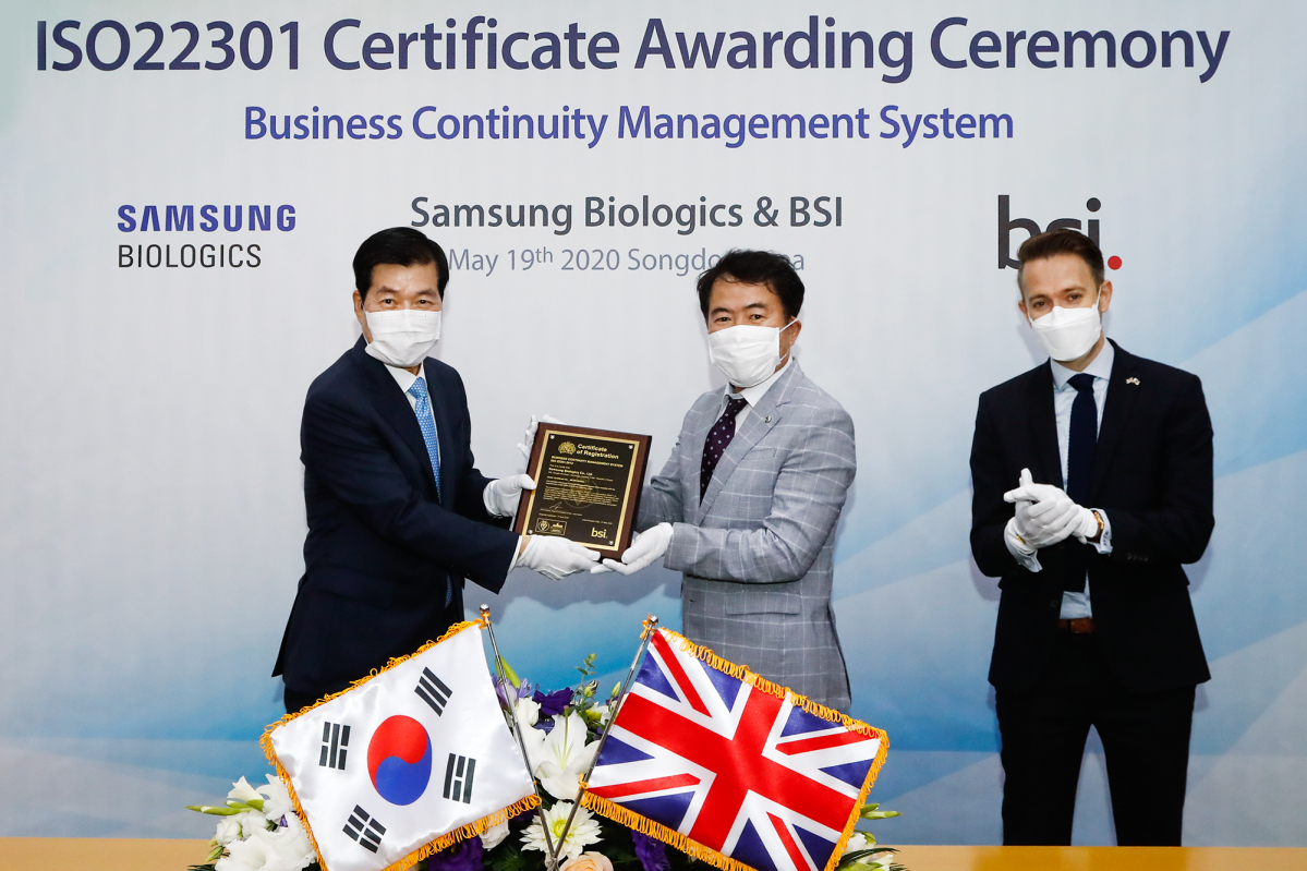▲김태한 삼성바이오로직스 사장(왼쪽)과 송경수(BSI) 총괄책임(가운데)이 주한영국대사관 마크 버티지 경제참사관이 수여한 'ISO 22301' 인증서를 들어보이고 있다. (사진제공=삼성바이오로직스)