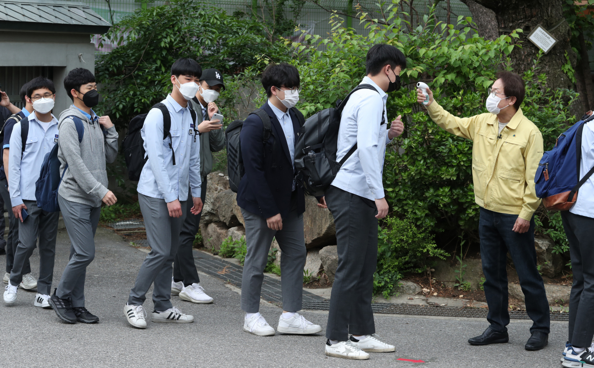 ▲코로나19로 등교 개학이 미뤄진 지 80일만에 등교를 시작한 20일 오전 서울 종로구 경복고등학교에서 조희연 서울시교육감이 등교하는 학생들에게 발열 체크를 하고 있다. (연합뉴스)