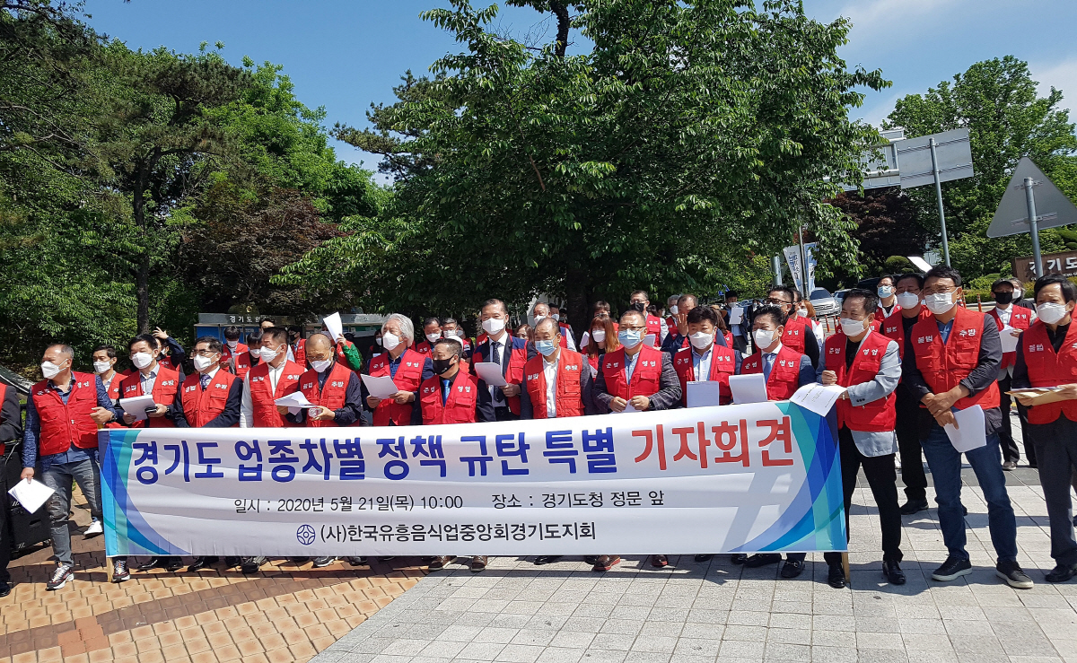 ▲한국유흥음식업중앙회경기도지회 관계자들이 21일 경기도청 정문 앞에서 업종차별 정책 규탄 기자회견을 열고 있다. 연합뉴스