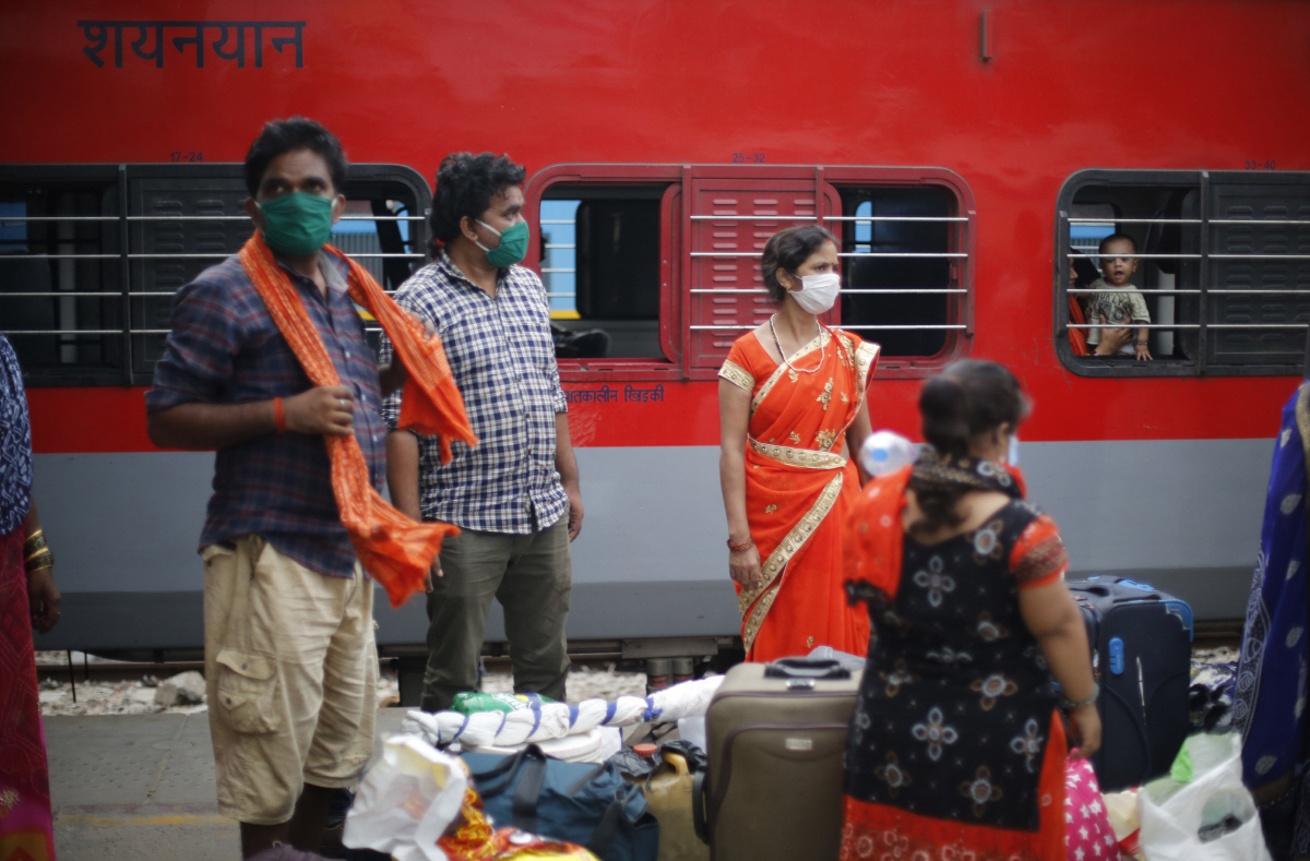 ▲인도 프라야그라지시의 한 기차역에 30일(현지시간) 이주 노동자들이 자신들을 수송한 열차 밖에 서 있다. 인도 정부는 코로나19 확산이 계속되는 상황에서도 경기침체에서 벗어나고자 6월부터 단계적인 봉쇄 완화에 들어갈 방침이다. 프라야그라지/AP뉴시스 
