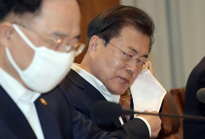 ▲문재인 대통령이 지난 3월 24일 청와대에서 열린 신종 코로나바이러스 감염증(코로나19) 관련 제2차 비상경제회의에 참석해 마스크를 벗고 있다. 뉴시스