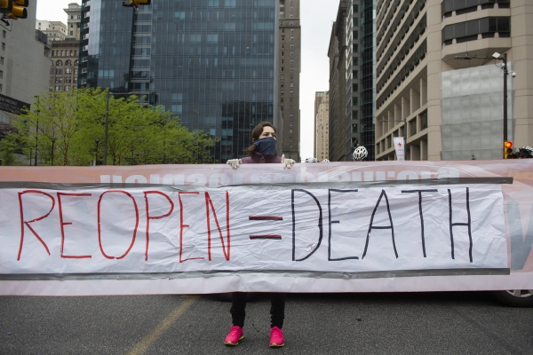 ▲미국 펜실베이니아주 필라델피아에서 8일(현지시간) 한 여성이 “봉쇄 해제는 죽음”이란 플래카드를 들고 시위하고 있다. 필라델피아/AP뉴시스