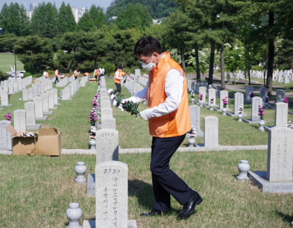 ▲김연철 한화시스템 대표이사가 참배 후 묘역 정화 활동에 참여하고 있다. (사진제공=한화)