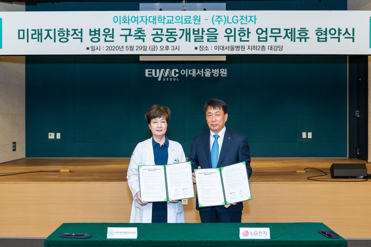 ▲이화여자대학교 의료원과 LG전자 관계자들이 지난달 29일 업무제휴 협약식에서 협약서를 들어보이고 있다.  (이화여자대학교 의료원)