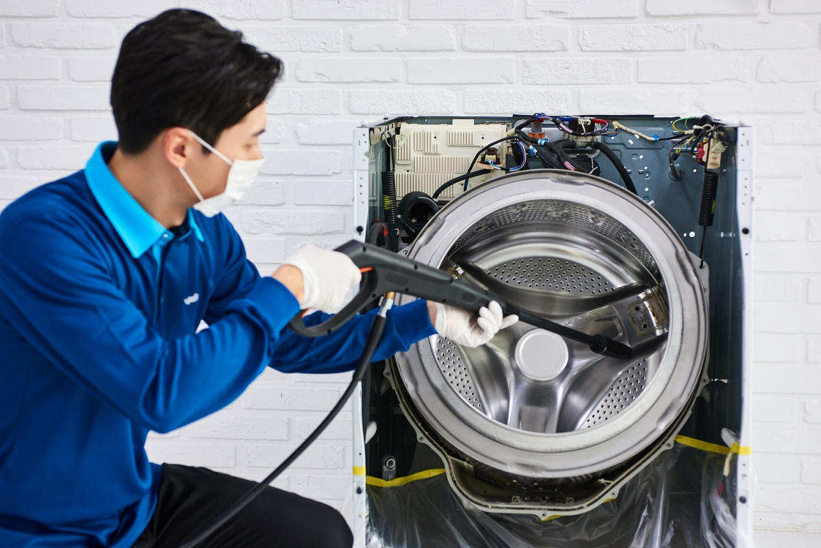 ▲웰스 홈마스터가 세탁기를 분해 세척하는 홈케어 서비스를 하고 있다. (사진제공=웰스)
