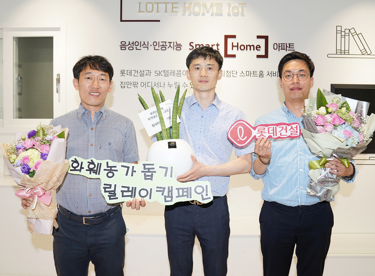 ▲롯데건설 대구 C/S센터 근무자들이 꽃다발과 공기정화 식물이 담긴 화분을 들고 기념사진을 찍고 있다. (사진 제공=롯데건설)