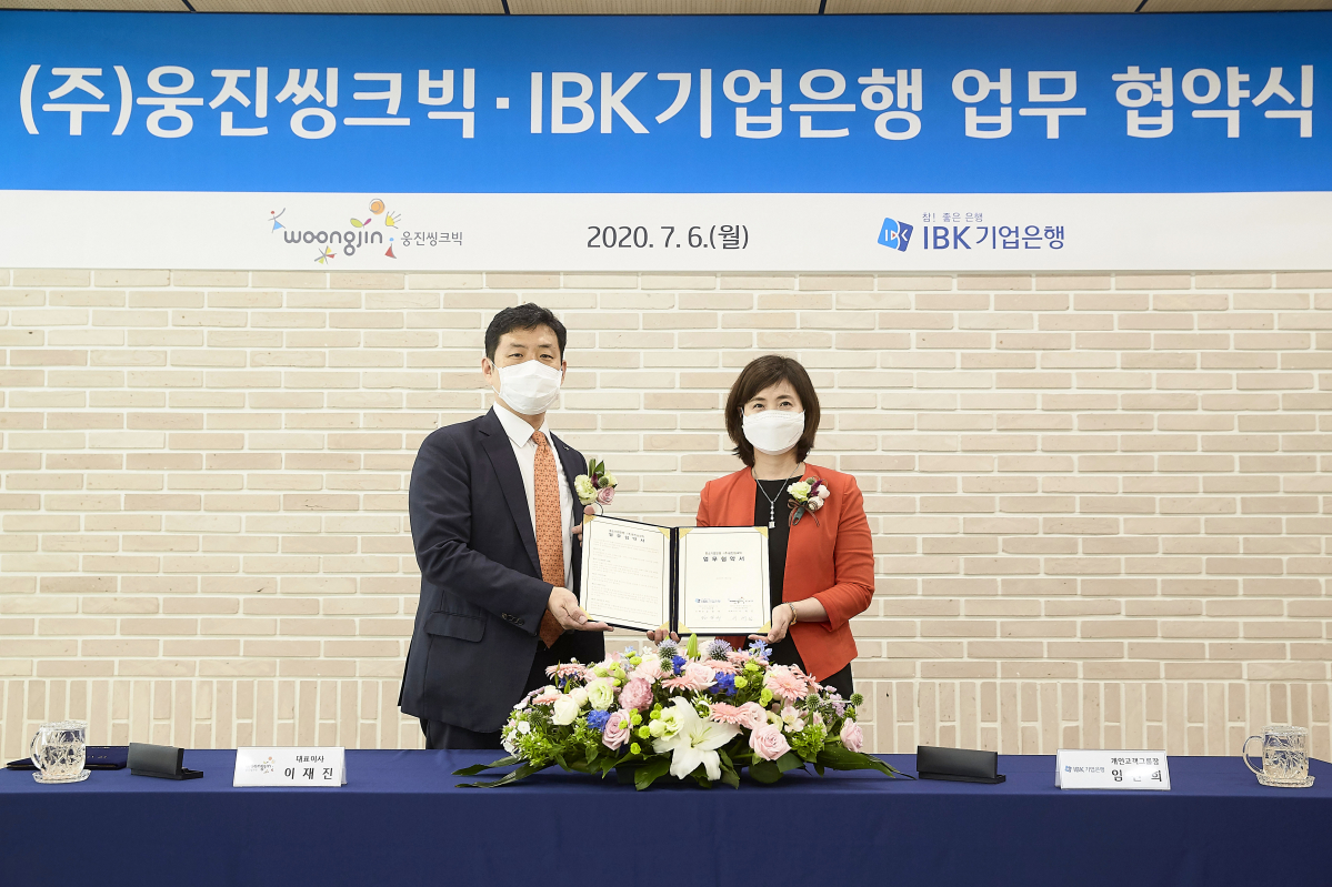 ▲이재진 웅진씽크빅 대표이사(왼쪽)와 임찬희 IBK기업은행 부행장이 'IBK웅진스마트올통장' 업무협약을 체결하고 기념촬영하고 있다. (사진제공=웅진씽크빅)