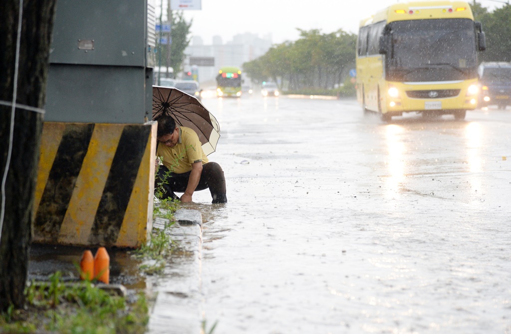 ▲폭우로 막힌 하수구를 뚫고 있는 전주시청 관계자. (뉴시스)