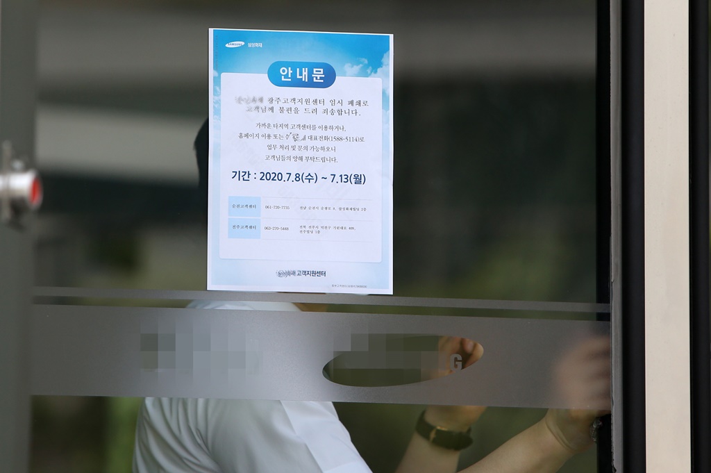 ▲8일 광주 서구 치평동의 한 건물이 신종 코로나바이러스 감염증(코로나19) 확진자 발생으로 폐쇄되며 건물 관계자가 출입문을 걸어 잠그고 있다.  (연합뉴스)