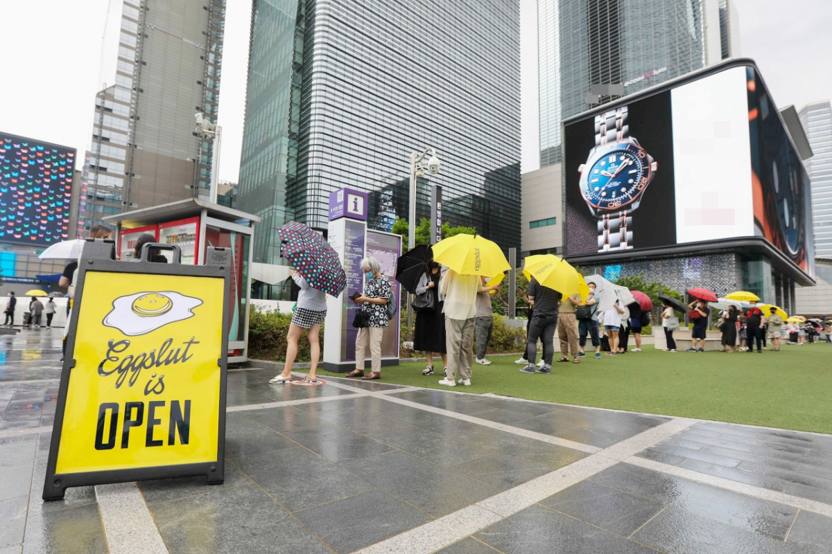 ▲10일 삼성역 코엑스몰 밀레니엄 광장에 문을 연 '에그슬럿' 국내 1호점에 고객들이 빗속에서 입장을 기다리며 줄을 서 있다. (사진제공=SPC삼립)