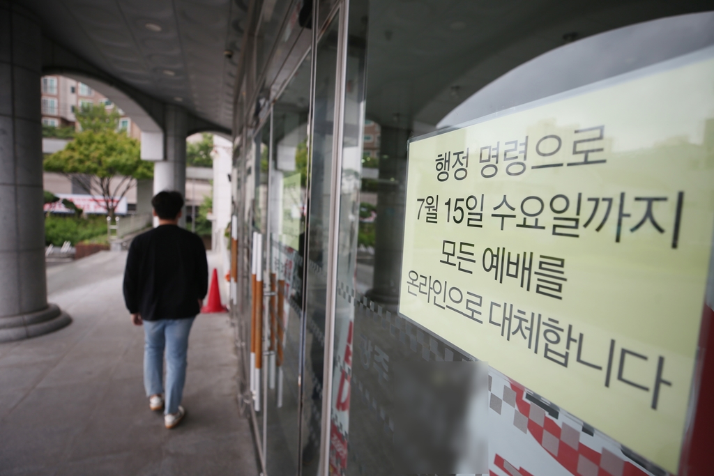 ▲12일 오전 광주 남구 한 대형 교회 출입문에 예배를 온라인으로 전환한다는 안내문이 붙어 있다. 광주시는 최근 코로나19 지역감염이 확산하자 거리두기를 2단계로 격상하고 실내 50인, 실외 100인 이상 모이는 모든 모임을 금지했다. (연합뉴스)