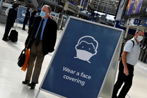 ▲영국 런던 워털루역에서 6일(현지시간) 행인 2명이 마스크를 낀 채 마스크 착용 안내판 옆에 서있다. 런던/로이터연합뉴스
