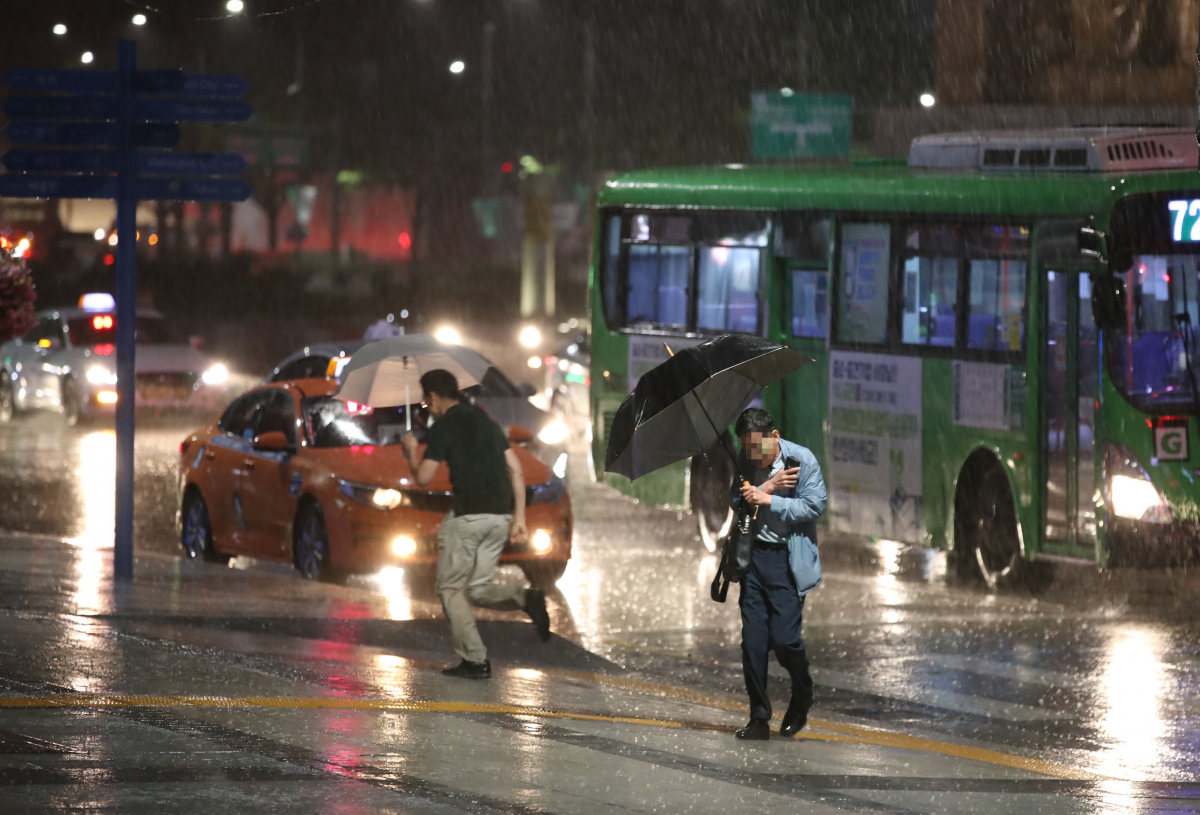 ▲서울 지역에 장대비가 내린 13일 오후 서울 종로구 광화문광장 인근에서 우산을 쓴 시민들이 발걸음을 서두르고 있다. (연합뉴스)