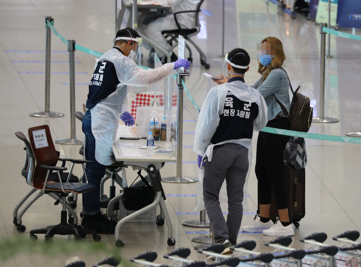 ▲인천국제공항에서 입국객이 관계자로부터 코로나19 검역에 대해 설명을 듣고 있다.  (사진제공=연합뉴스)