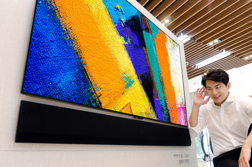 ▲LG전자가 벽 밀착 LG 올레드 갤러리 TV와 완벽하게 어울리는 갤러리 디자인 사운드 바를 출시한다. 이 제품은 동급 제품 대비 두께가 절반 이상 얇고, 벽에 밀착하는 디자인으로 TV와 함께 설치하면 마치 하나의 제품처럼 보인다. 모델이 갤러리 디자인 사운드 바 신제품을 소개하고 있다. (사진제공=LG전자)