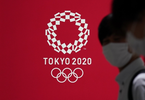 ▲일본 도쿄에서 15일(현지시간) 마스크를 착용한 시민들이 도쿄올림픽 로고 앞을 지나고 있다. 도쿄/EPA연합뉴스

