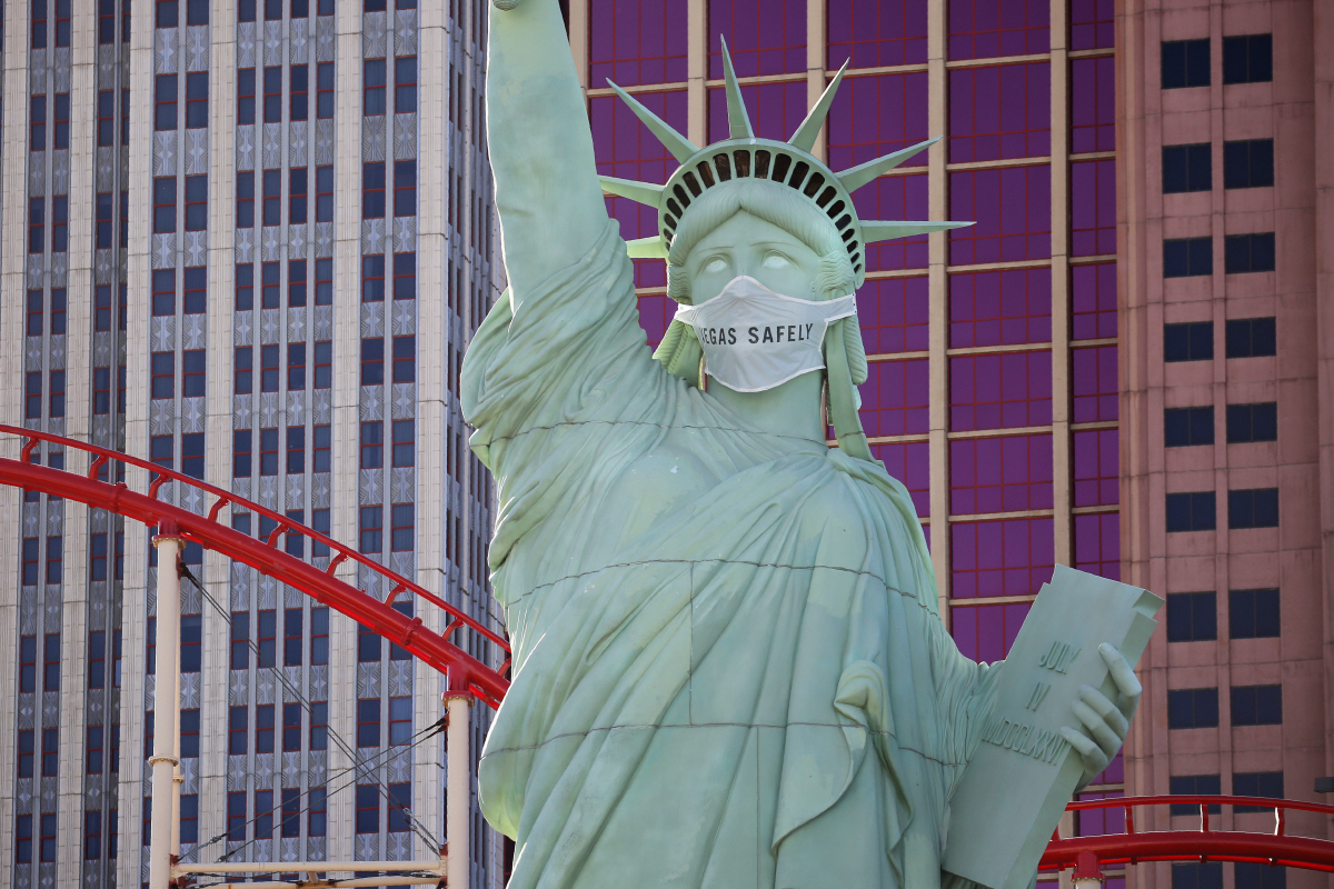 ▲16일(현지시간) 미국 네바다 주 라스베이거스의 ‘뉴욕-뉴욕 호텔 앤드 카지노’ 앞 자유의 여신상 복제품에 신종 코로나바이러스 감염증(코로나19) 예방 마스크가 씌워져 있다. 라스베이거스/AP연합뉴스