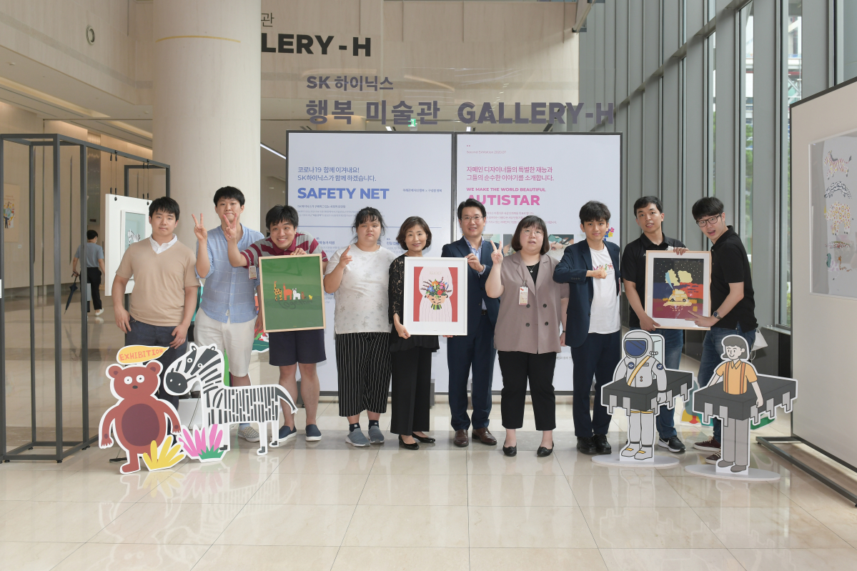 ▲기념식에 참석한 SK하이닉스 관계자와 ‘오티스타’ 소속 자폐인 디자이너들이 사진을 찍고 있다. 왼쪽 다섯 번째부터 오티스타 이소현 대표, SK하이닉스 이일우 EE담당 (사진제공=SK하이닉스)