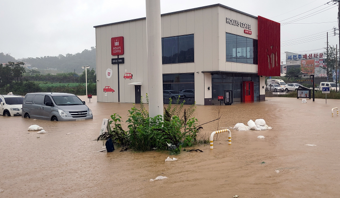▲30일 호우경보가 내려진 전북 전주시 완산구 한 커피숍과 의류매장 주차장이 물에 잠겨 있다. (연합뉴스)
