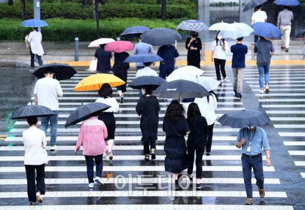 ▲전국에 본격적인 장마가 시작된 지난달 24일 서울 세종대로에서 우산을 쓴 시민들이 발걸음을 옮기고 있다. (신태현 기자 holjjak@)