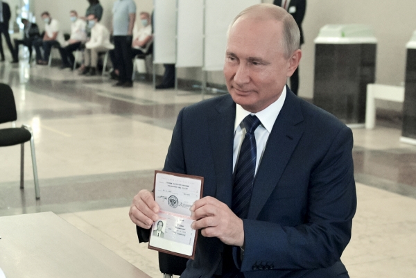 ▲블라디미르 푸틴 러시아 대통령이 1일(현지시간) 러시아 모스크바의 한 투표소에 도착해 신원 확인을 위해 선거관리위원회 관계자에게 여권을 보여주고 있다. 모스크바/AP뉴시스
