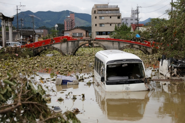 ▲폭우로 큰 피해를 입은 일본 구마모토현 히토요시에서 7일 파손된 교량 부근에 전복된 차량 1대와 차체 일부가 물에 잠긴 버스가 방치돼 있다. 히토요시/로이터연합뉴스
