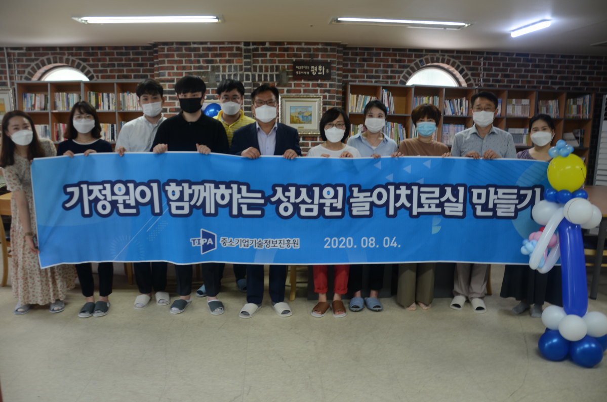 ▲이재홍 중소기업기술정보진흥원 원장(가운데)이 성심원 관계자, 기정원 직원 일동과 놀이치료실 앞에서 기념 촬영을 하고 있다.  (사진제공=중소기업기술정보진흥원)