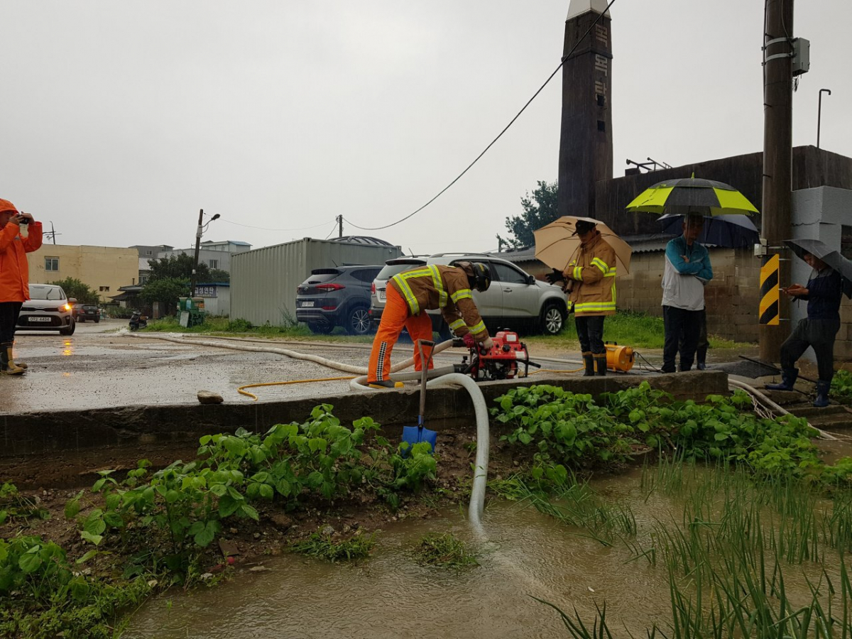 ▲5일 고성군에 호우경보와 함께 시간당 10~30mm의 장맛비가 쏟아지면서 산사태가 발생하고 하천이 범람하는 등 피해가 속출하고 있는 가운데, 고성소방서 대원들이 산사태, 토사, 축사 소실 등 각종 비 피해 현장에 출동해 복구 작업을 벌이고 있다. (뉴시스)