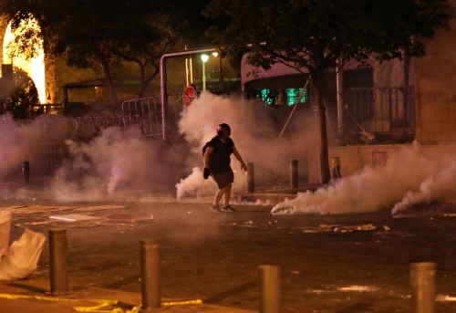 ▲레바논 베이루트에서 7일(현지시간) 반정부 시위 참가자가 헬멧을 쓴 채 최루탄 가스가 피어오르는 거리를 걷고 있다. 베이루트/로이터연합뉴스
