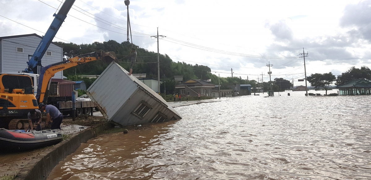▲9일 영산강 대홍수로 침수된 전남 나주시 다시면 죽산 마을에서 주민들이 중장비를 동원해 컨테이너 가건물을 옮기고 있다. (뉴시스)