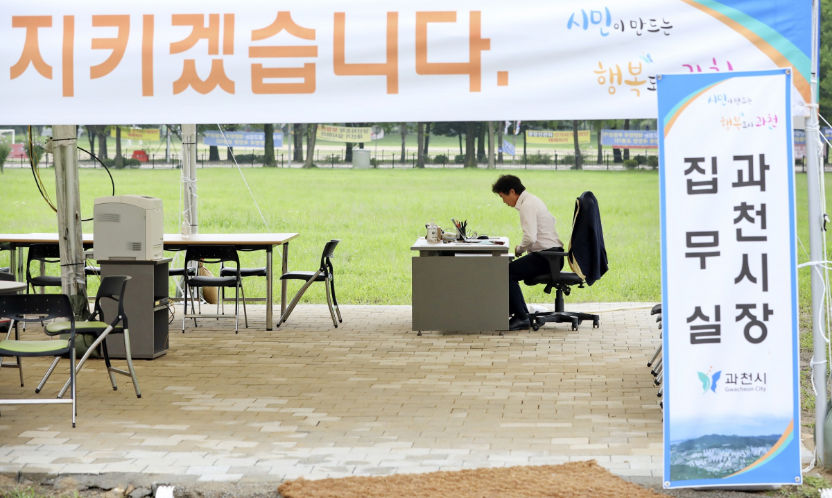 ▲김종천 과천시장이 7일 경기 정부과천청사 유휴 부지에 차려진 천막 시장실에서 업무를 보고 있다. 김 시장은 정부과천청사 유휴 부지에 4000가구를 공급하겠다는 계획 철회를 촉구 하며 지난 5일 해당 부지에 천막 시장실을 설치했다. (뉴시스)