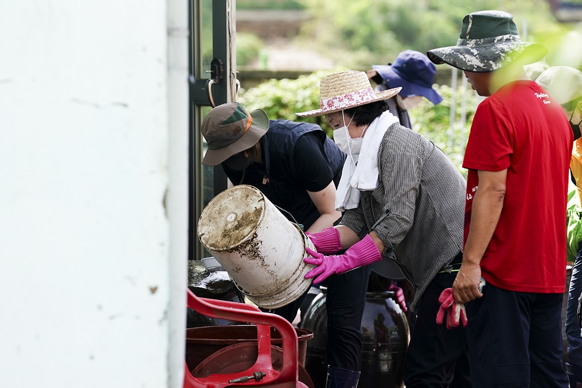 ▲영부인 김정숙 여사가 강원도 철원 수해 현장에서 고무장갑을 끼고 가재도구를 닦고 있다. (청와대 제공)