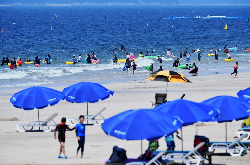 ▲장마가 소강상태를 보이며 무더위가 찾아왔다. 전국 대부분 지역에 폭염특보가 내려진 13일 충남 보령시 대천해수욕장을 찾은 시민들이 파란 하늘 아래서 해수욕을 즐기고 있다. 신태현 기자 holjjak@ (이투데이DB)