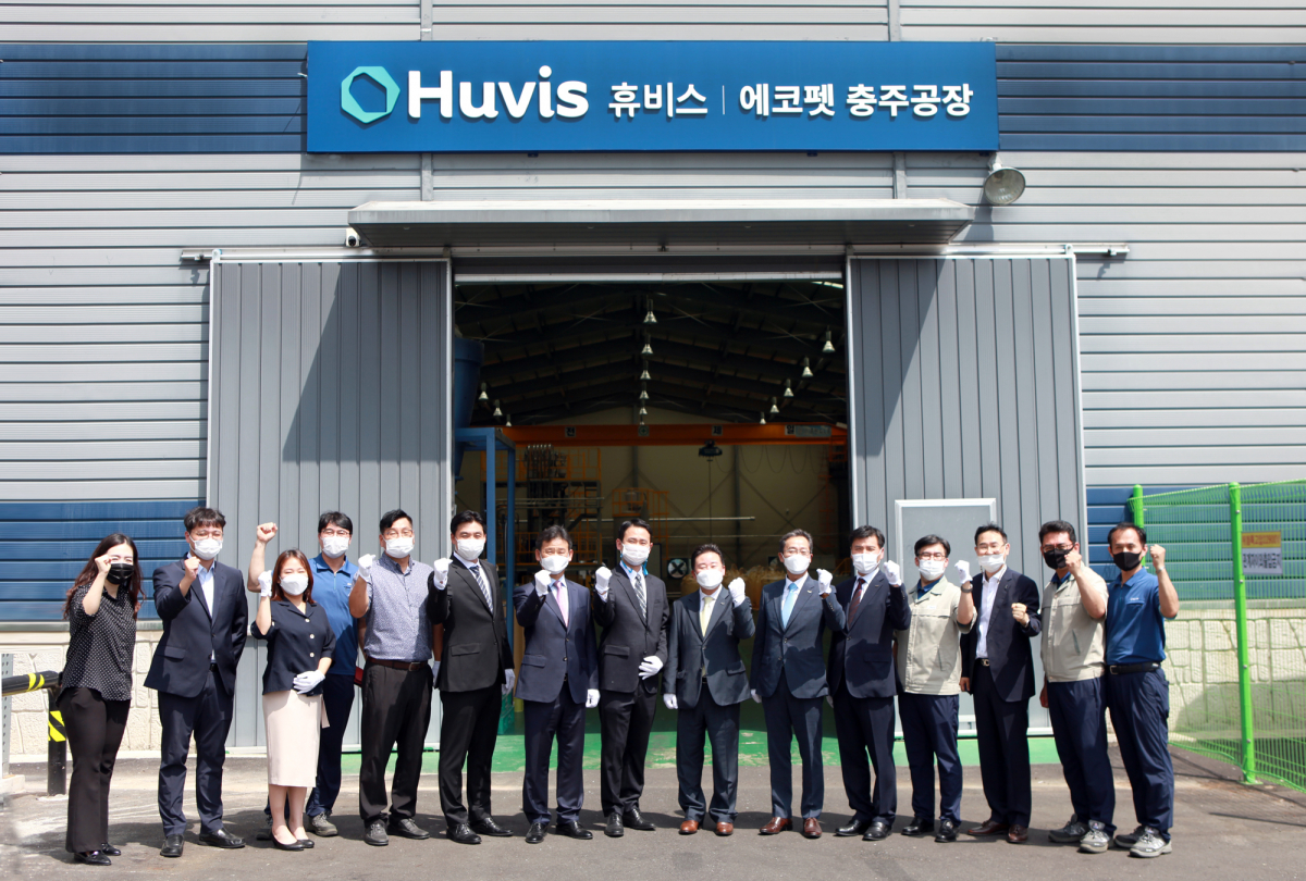 ▲신유동(오른쪽 일곱번 째) 휴비스 대표이사와 이에스 임직원들이 에코펫 충주공장 현판식에서 기념사진을 찍고 있다. (사진제공=휴비스)