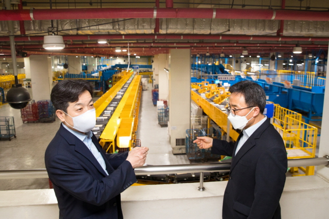 ▲장석영 과학기술정보통신부 제2차관(왼쪽)이 지난 6월 3일 오후 서울 광진구 동서울우편집중국을 방문해 박상태 동서울우편집중국장으로부터 대형 통상우편물을 구분하는 '팻킷구분기' 에 대한 설명을 듣고 있다. (과기정통부 제공)
