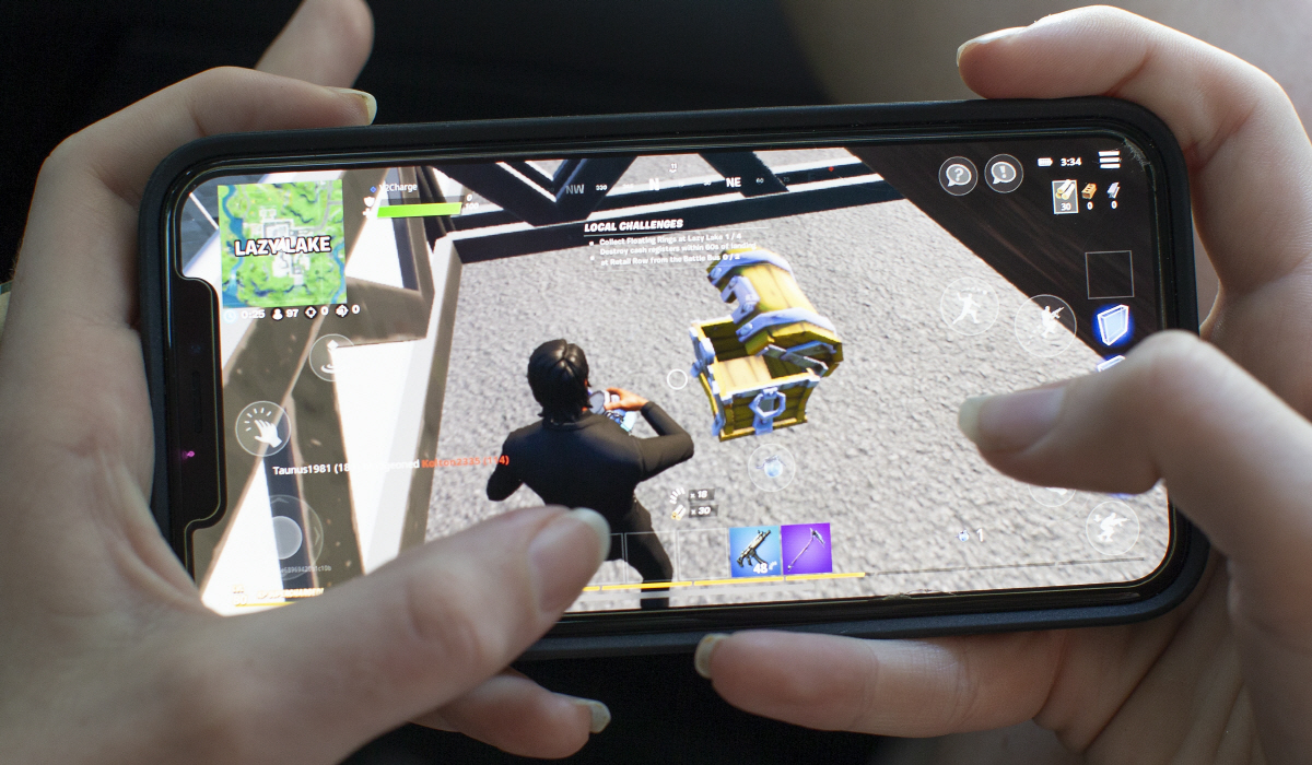 ▲미국에서 한 어린이가 애플 아이폰으로 에픽게임스의 인기 게임 ‘포트나이트’를 즐기고 있다. EPA연합뉴스