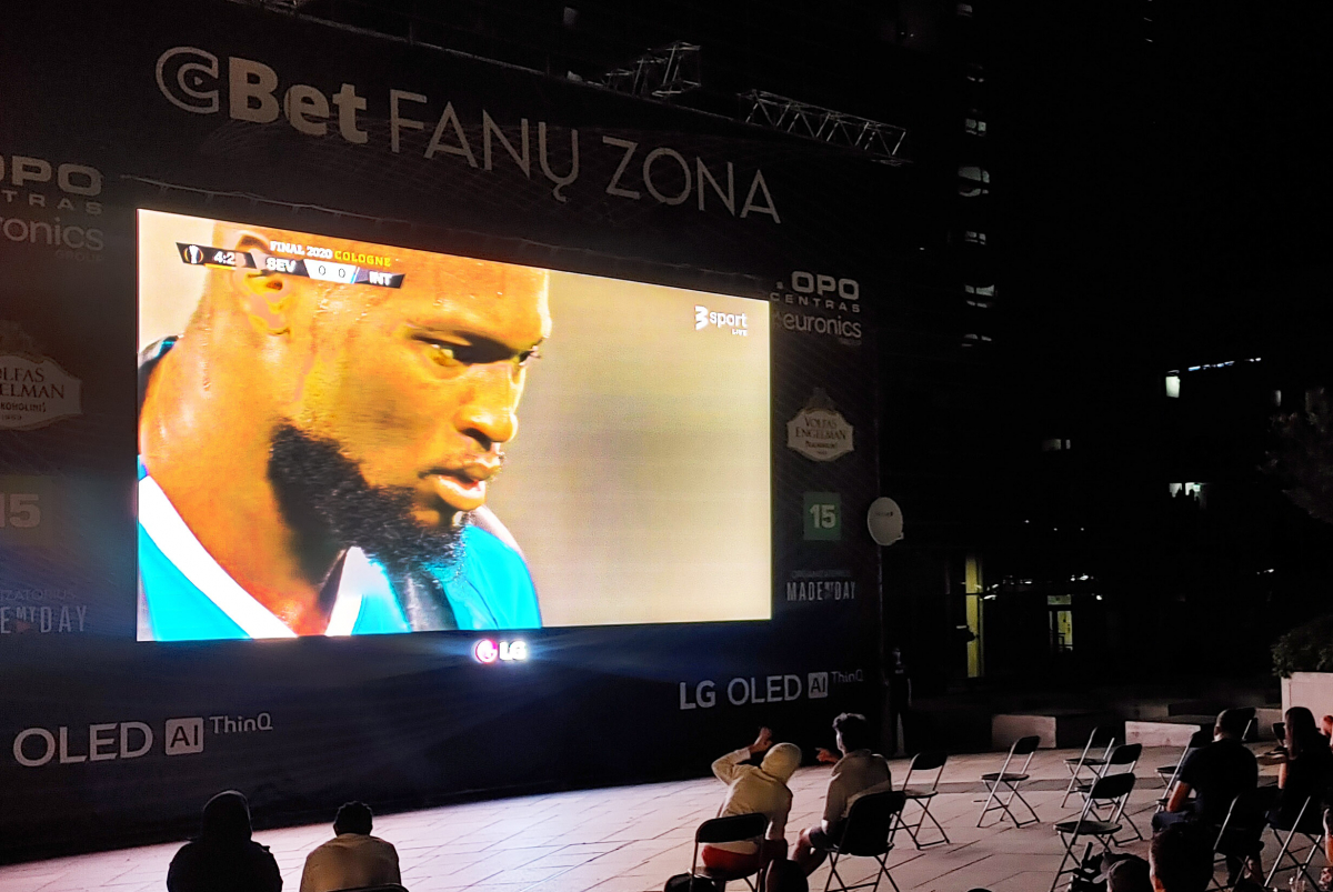 ▲LG전자가 최근 유럽에서 열린 대형 스포츠 이벤트와 연계한 LG 올레드 TV 옥외광고를 진행하며 축구팬들의 이목을 사로잡았다. LG전자는 ‘Best TV for watching sports’라는 슬로건을 내걸고 해외 축구팬들에게 LG 올레드 TV의 장점을 알리는 한편, 대형 화면을 통해 올레드 TV 광고 영상도 소개했다. 리투아니아 수도 빌니우스시 중심가에 위치한 광장에 축구팬들이 모여 축구경기를 관람하는 모습. (사진제공=LG전자)